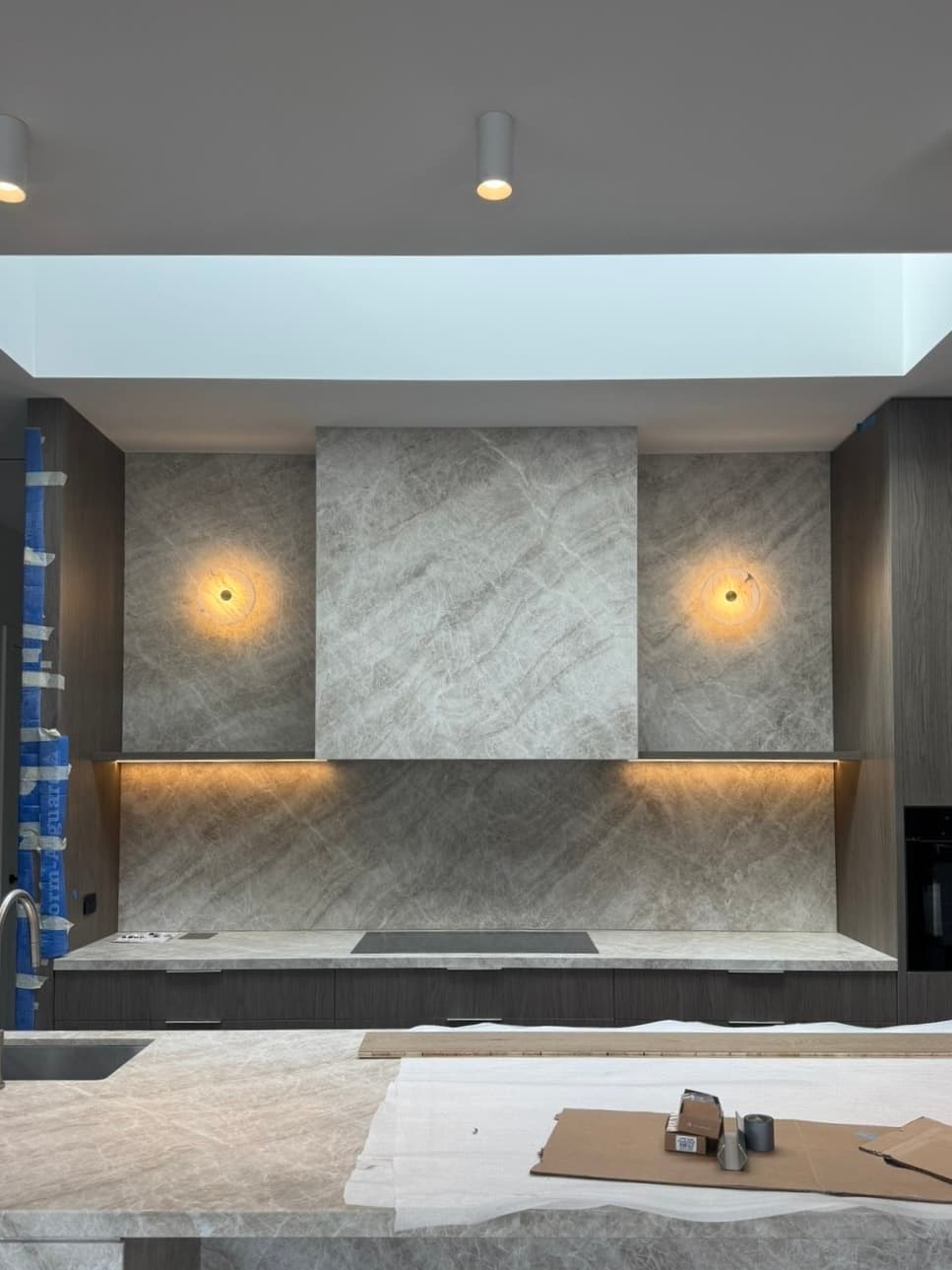 Luxury kitchen with designer wall sconces and under-cabinet lighting